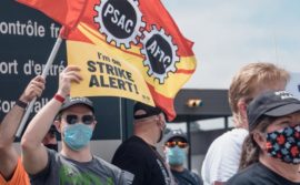 Membres du SDI qui manifestent avec une pancarte "I'm on strike alert"